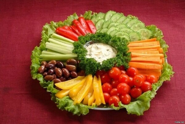 Colourful plate with fresh greens and fruit — a light snack idea